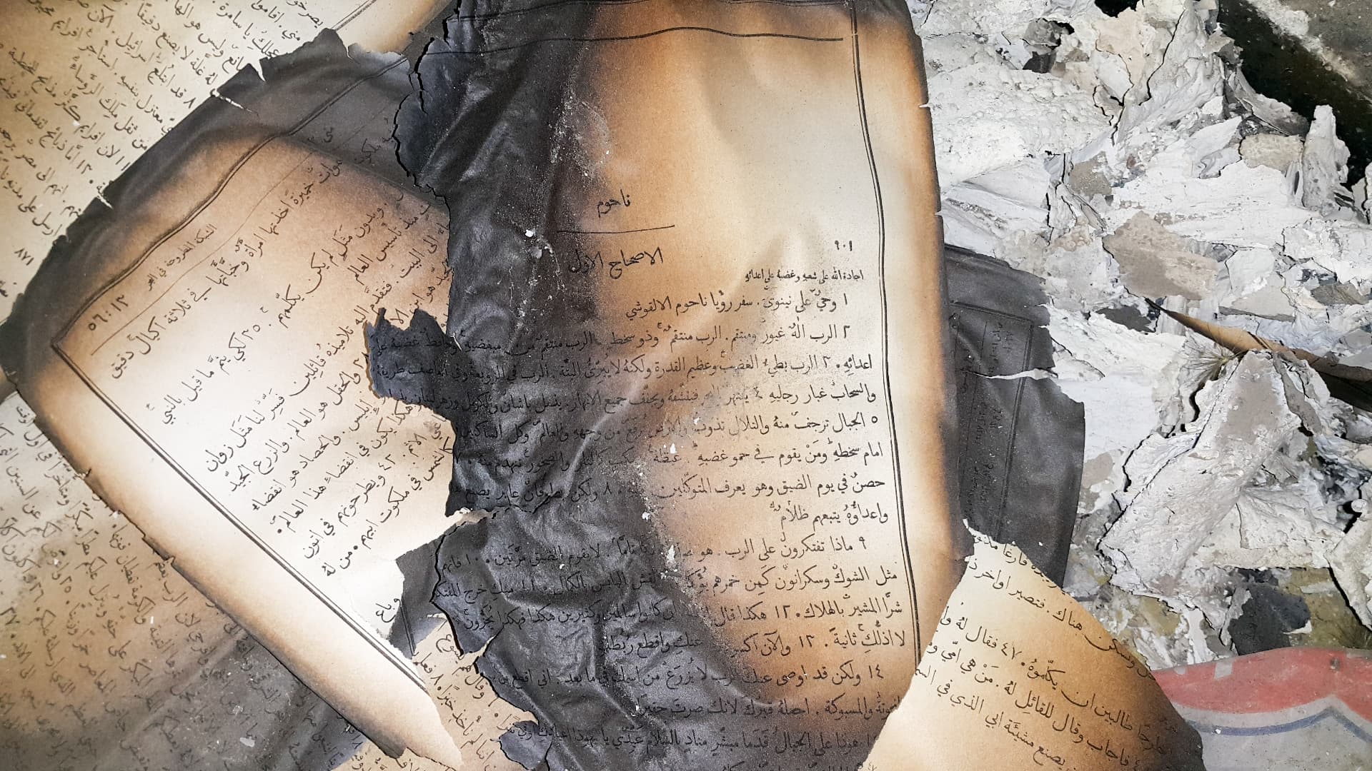 Verbrande bijbelpagina's in een uitgebrand christelijk huis