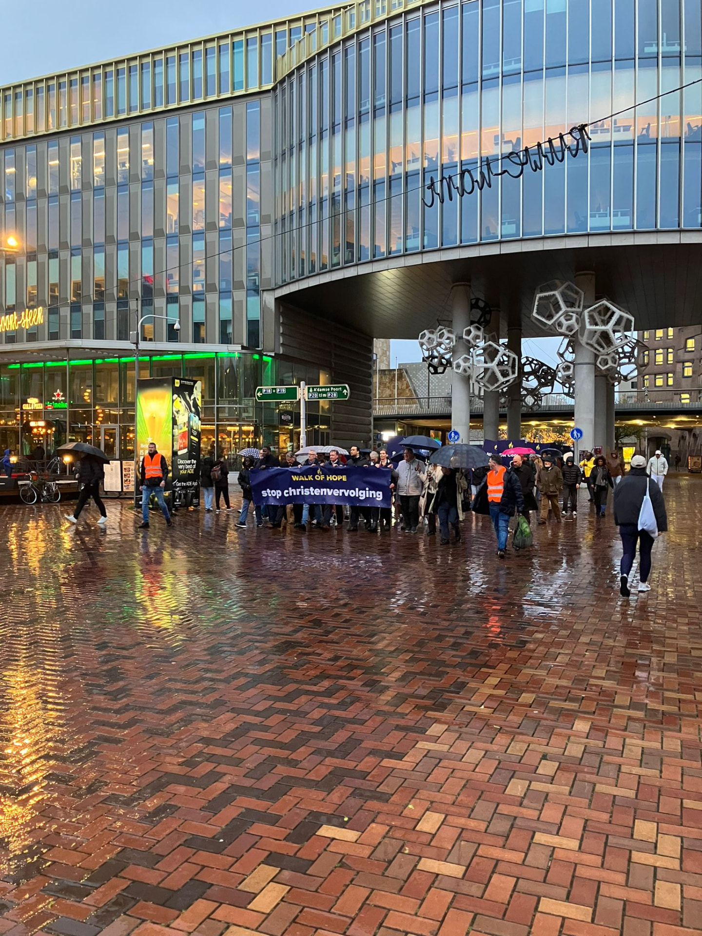 De stille tocht loopt door de regen langs het station